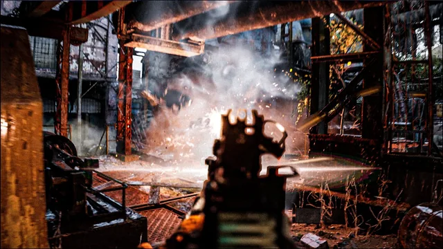 Rifle sights facing smoke and sparks in a derelict industrial interior.